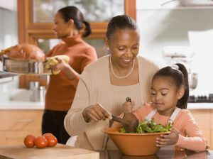 African grandmother, mother and daughter preparing food