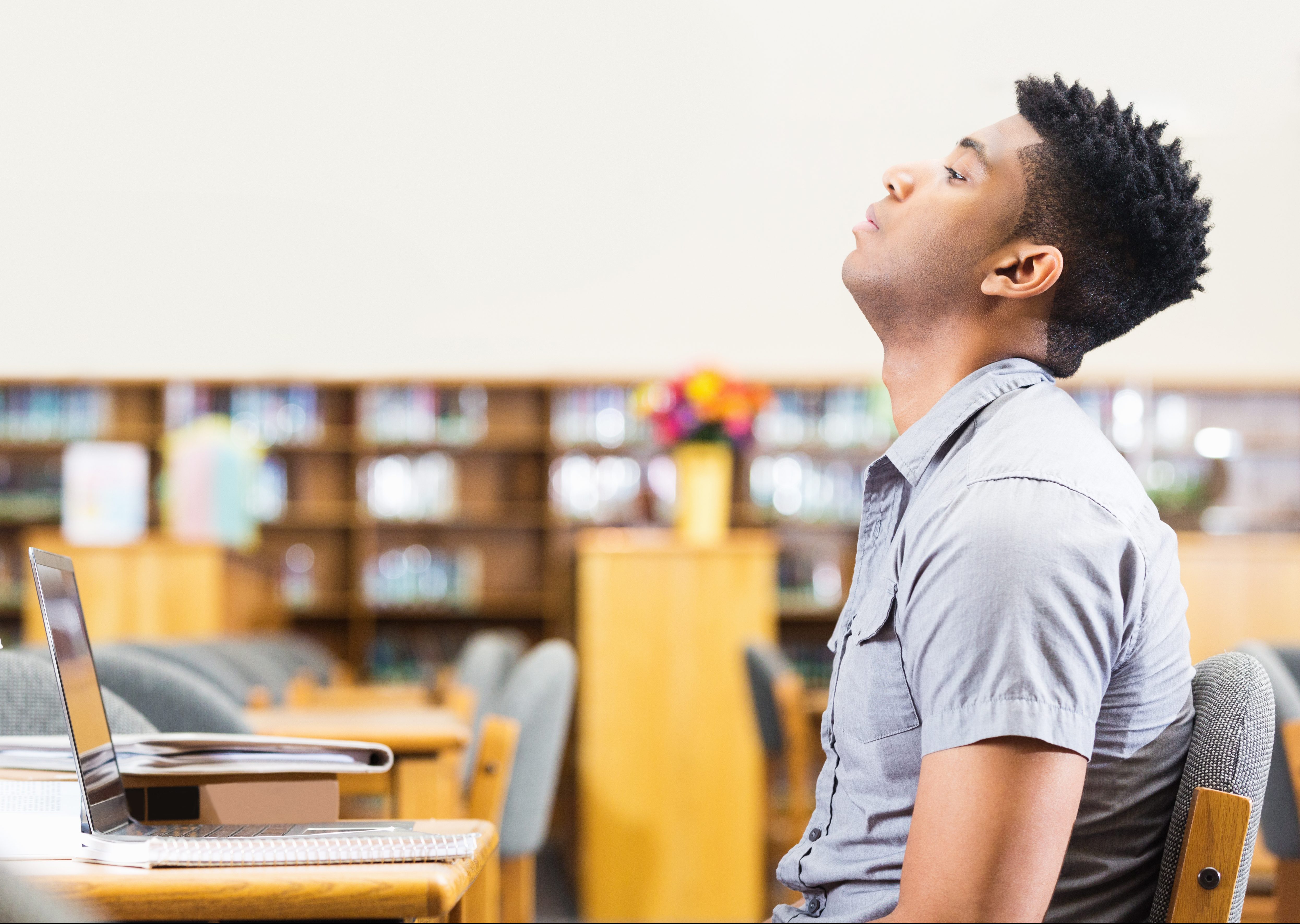 Tired or frustrated African American student studying late in library