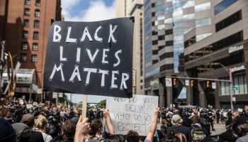 A protester holds a placard that says Black Lives Matter...