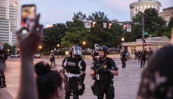 Riot police stand on guard outside the state house during...