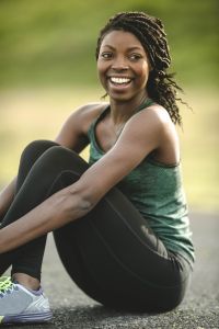 African American woman doing yoga outside by river