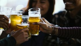 Close-up of happy friends toasting beer glasses in pub