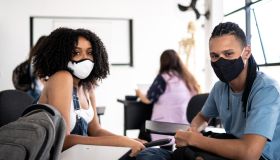 Portrait of friends wearing face mask in class room