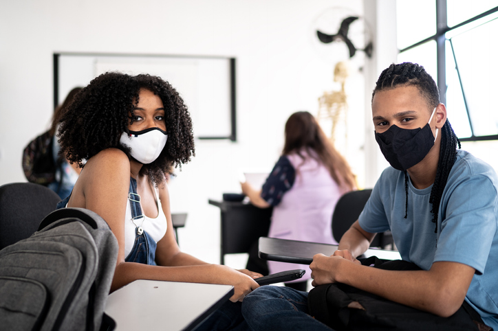 Portrait of friends wearing face mask in class room