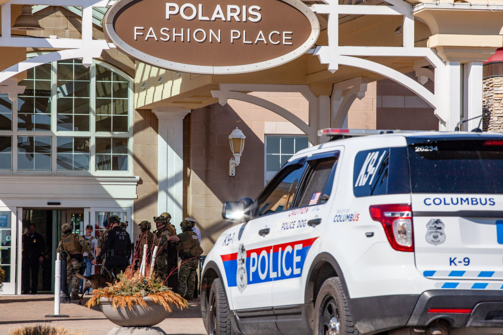 Police officers enter the Polaris Fashion Place. Around 12:...