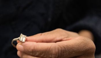 black woman holds diamond engagement ring