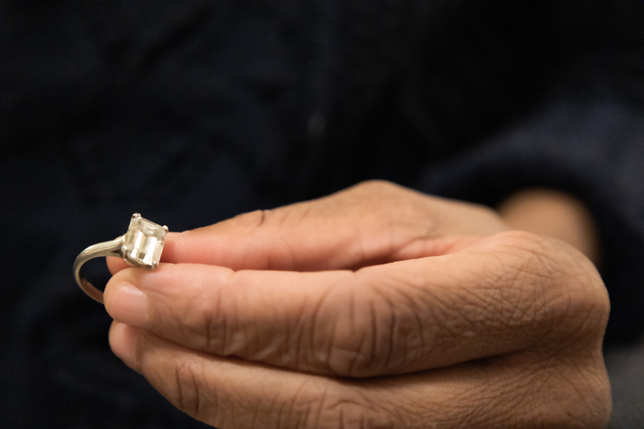 black woman holds diamond engagement ring