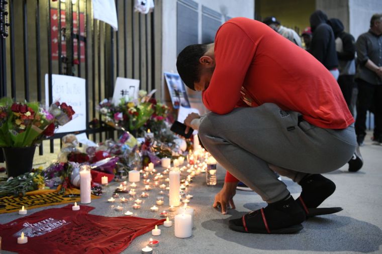A fan has a quiet moment at the vigil for Dwayne Haskins Jr.