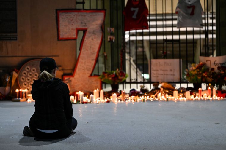 A fan has a quiet moment during the vigil for Dwayne Haskins Jr.