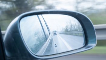 A car drives along a highway. View through the rear-view mirror of the vehicle. . Germany.