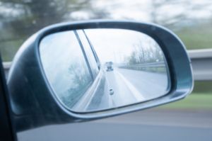 A car drives along a highway. View through the rear-view mirror of the vehicle. . Germany.