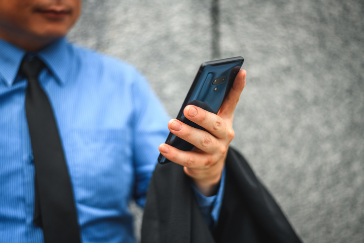Well-Dressed Male Businessman Holding A Smart Phone