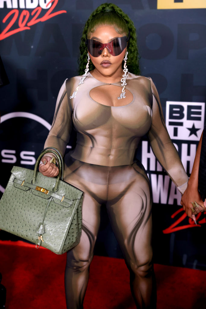 Lil Kim wearing Syndical Chamber with Yeezy Shades, and a Berkin Bag