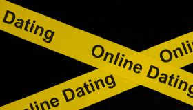 Online dating alert, caution and warning concept. Yellow barricade tape with word in dark black background.