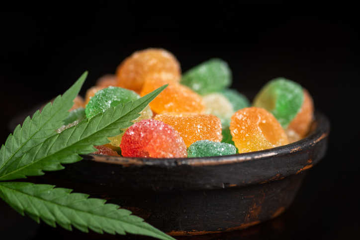 Colored candy gelatin in a black bowl with marijuana leaves