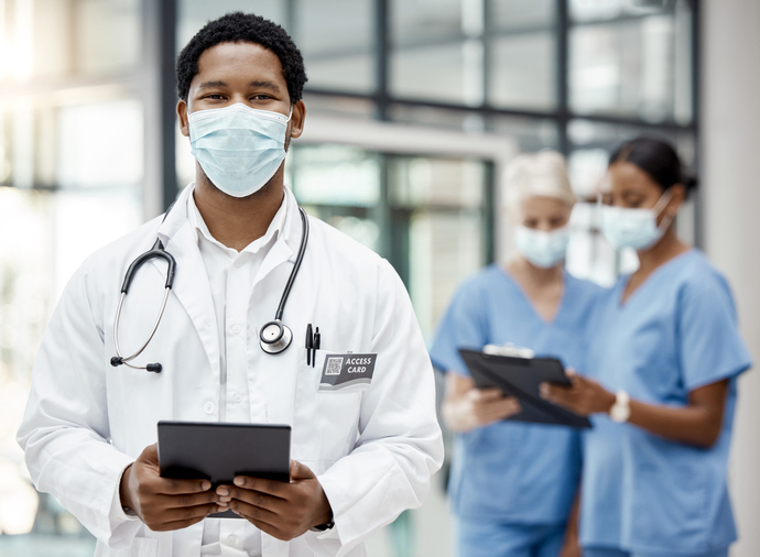 Covid, healthcare and African doctor with a tablet for online consulting, agenda and planning on tech at hospital. Medical, portrait and surgeon with technology for schedule and face mask at a clinic