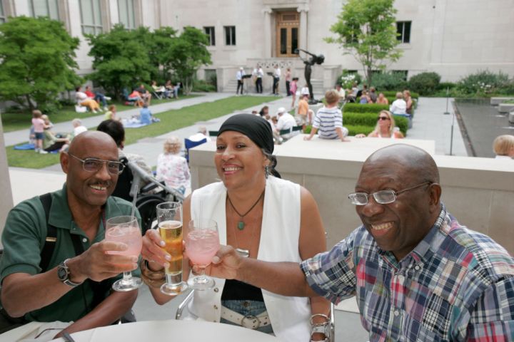 A group of friends smiling at the Jazz Picnic in the Courtyard.
