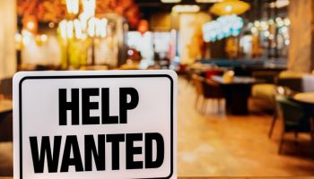 Help wanted sign inside restaurant. Food service industry jobs, labor shortage and unemployment concept.
