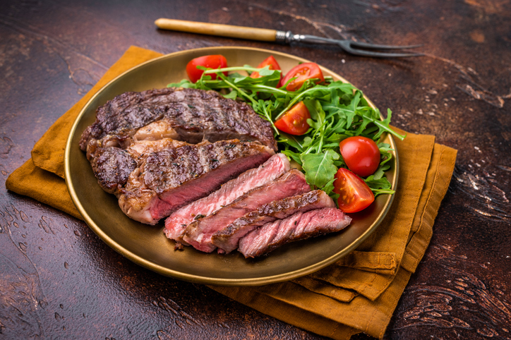 Dinner with Grilled Rib eye steak, fried dry aged beef meat. brown background. top view