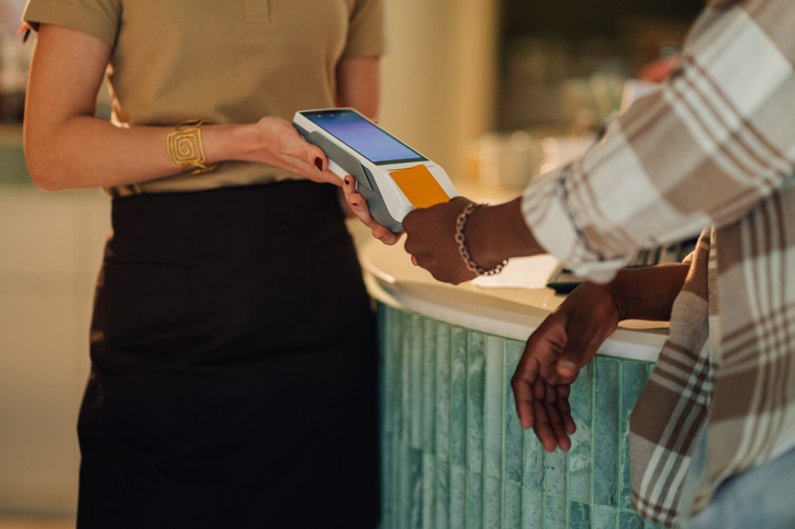 Customer making a contactless payment at a cafe