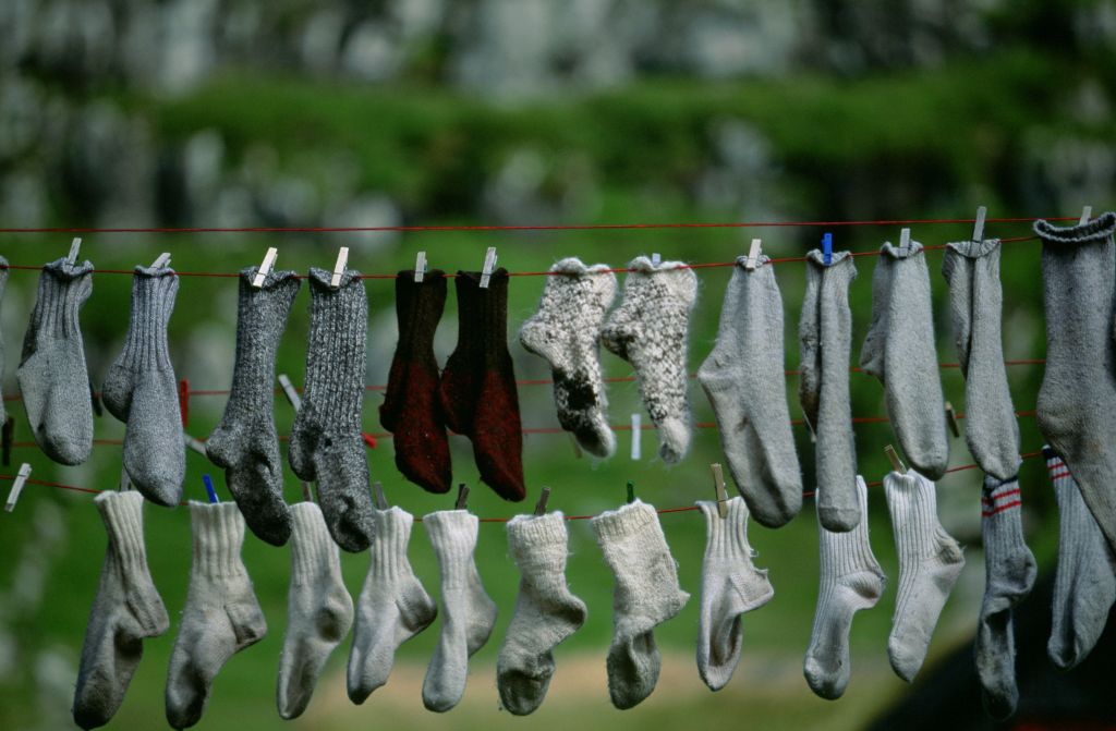 Several pairs of socks hang outside to dry on a clothes line, Faeroe Islands, Europe.