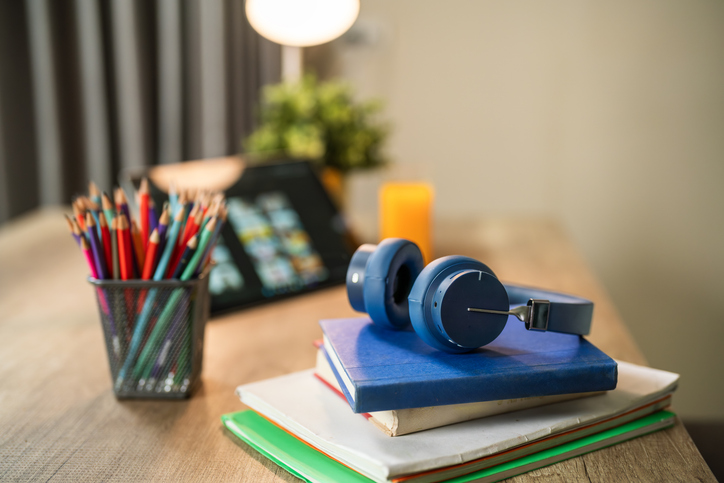 Headphones, books, and tablet for remote learning and studying