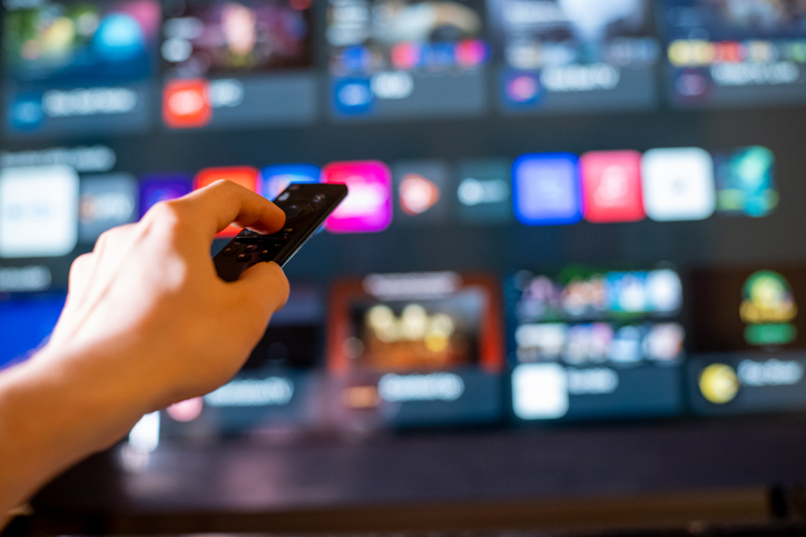 Close-Up of Hand Aiming Remote at Smart TV with